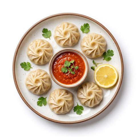 Steamed chicken momos with a spicy dipping sauce